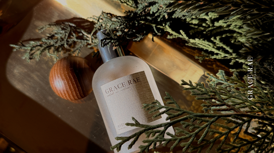 Bottle of Grace & Rae with acorn and pine branches on a wooden surface